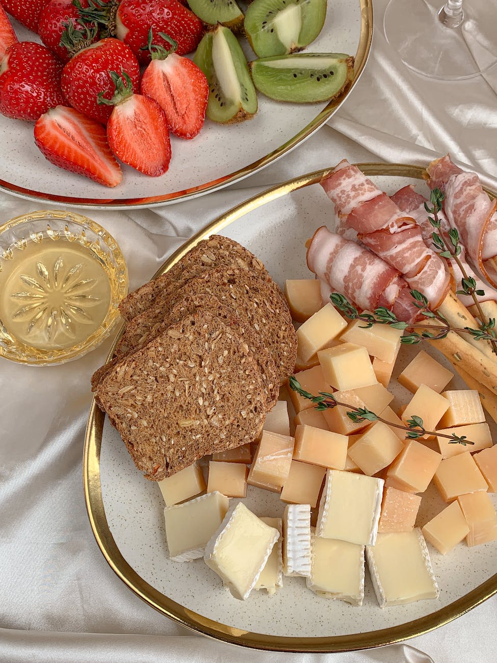 sliced bread with sliced strawberries and sliced fruits on clear glass plate